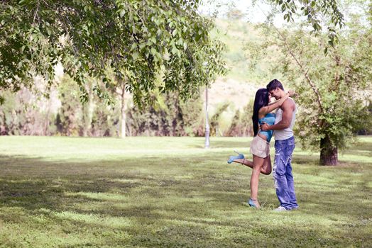 Attractive young couple kissing in a beautiful park