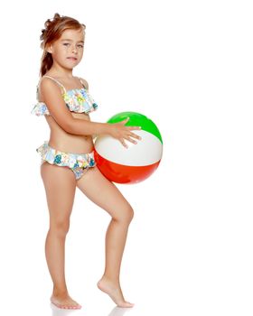 A little girl in a swimsuit is playing with a big ball. The concept of a family vacation at sea, happy childhood.Isolated on white background.