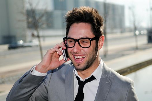 Portrait of handsome man in urban background talking on phone