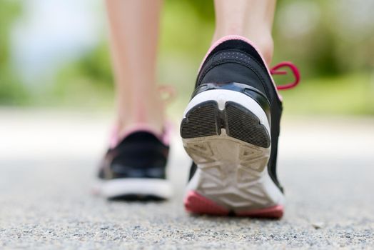 Woman feet running on road closeup on shoe