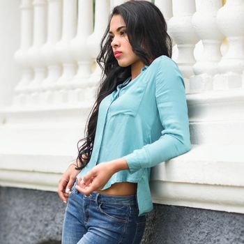 Portrait of hispanic young woman wearing casual clothes in urban background