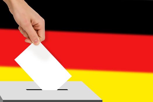 hand drops the ballot election against the background of the germany flag, concept of state elections, referendum