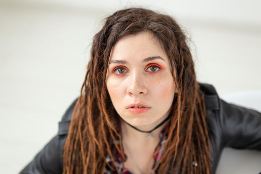 Dreadlocks, hairdresser and style concept - A funny girl with dreadlocks and in leather jacket and fashionable makeup.