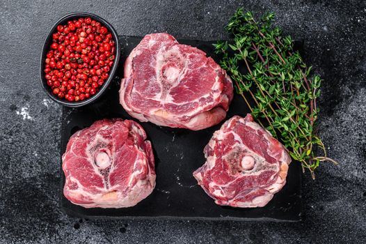 Raw lamb neck meat on a marble board..Black background. Top view.