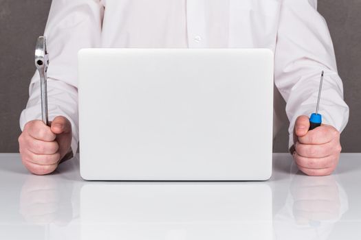 Close-up Of Technician Repairing Laptop At Desk