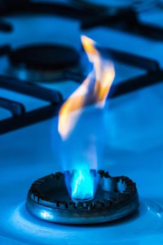 Gas burner with flame from a hole on a gas stove, close-up.