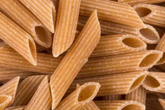 Wholemeal Pasta Penne as close-up shot for background