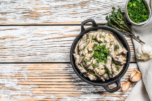 Beef stroganoff with mushrooms in frying pan. White background. Top view. Copy space.