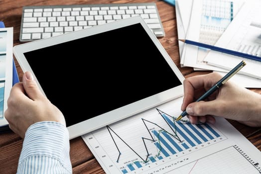 close-up, female hands with tablet. Business woman working at the table in the office