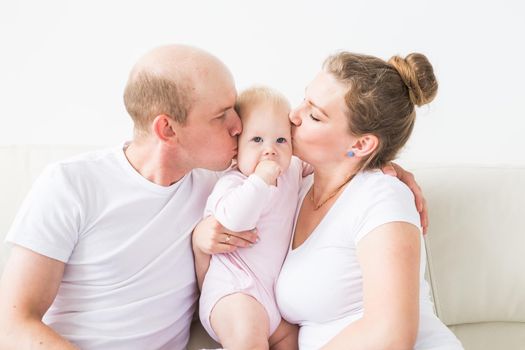 Happy family concept. Parents kissing baby smiling