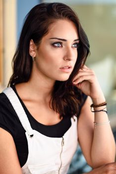 Close-up portrait of young woman with blue eyes outdoors. Girl looking away in casual clothes. Beauty and fashion concept.