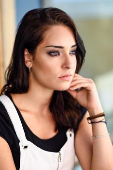 Close-up portrait of young woman with blue eyes outdoors. Girl looking away in casual clothes. Beauty and fashion concept.