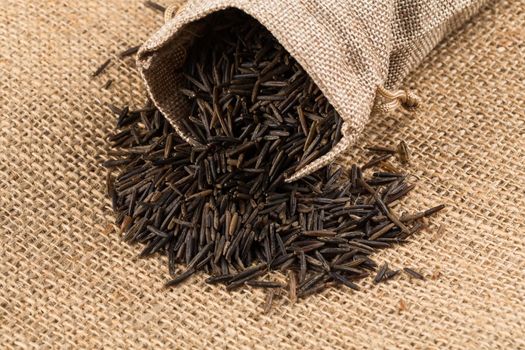 Close up image of a heap of wild rice in a hessian sack