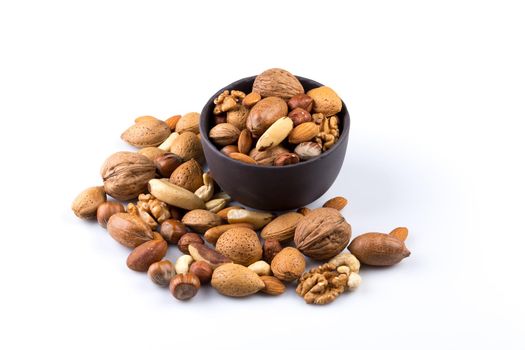 Large diversity of healthy nuts in a dark stone bowl - isolated