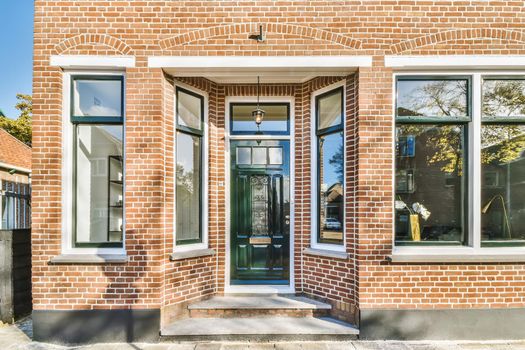 Entrance part of brick house with big windows