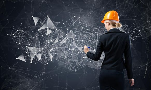 Businesswoman pointing on abstract 3d network. Back view of woman engineer in business suit and safety helmet. Social connection and networking. Futuristic technology concept with 3d plexus structure.