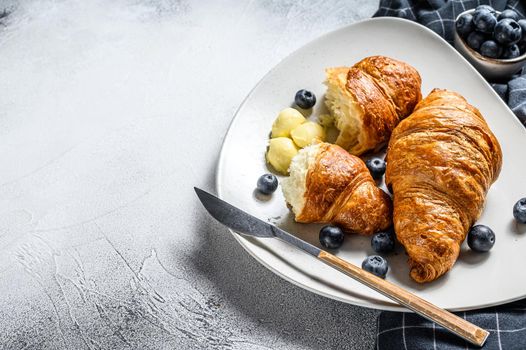 French buttery croissants with blueberry on a plate. Gray background. Top view. Copy space.