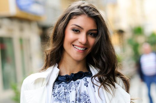 Portrait of a beautiful woman smiling in urban background