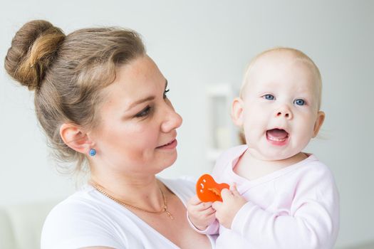 Childhood, family and motherhood concept - Mother holding sweet baby girl.