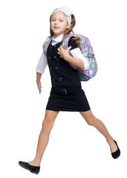 Happy little girl hurries to school . It carries over the shoulder school backpack - Isolated on white background