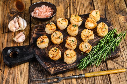 BBQ Seared scallops with butter sauce on a wooden board. wooden background. Top view.