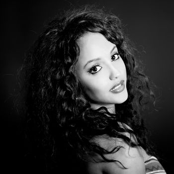 Portrait of attractive mixed woman on black background