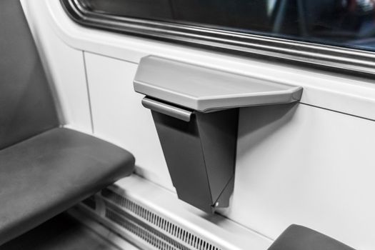 Compact waste bin in the interior of a modern stadler electric train.