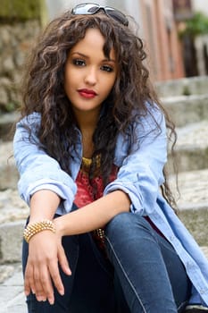 Portrait of attractive mixed woman in urban background wearing casual clothes