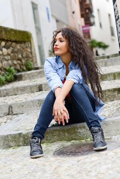 Portrait of attractive mixed woman in urban background wearing casual clothes