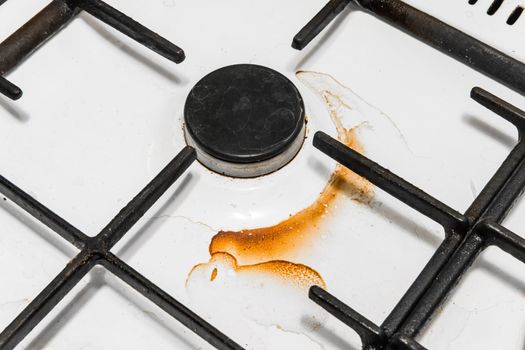 Dirty gas stove and burners after home cooking in the kitchen, close up.