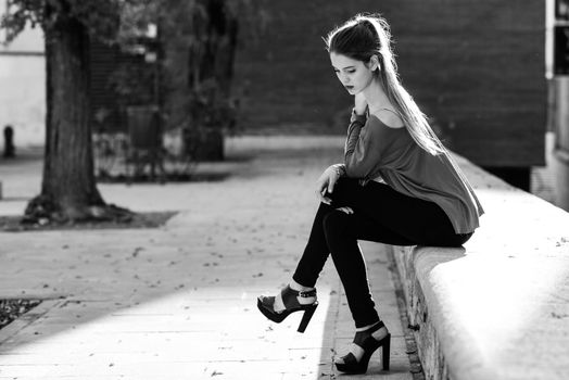Portrait of beautiful blonde girl in urban background