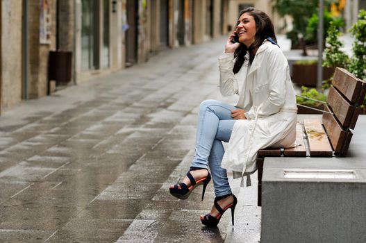 Portrait of beautiful young woman in urban background talking on phone