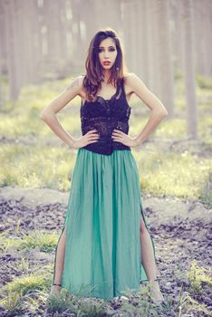 Portrait of beautiful young woman wearing long dress in a forest