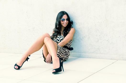 Funny female model at fashion with high heels sitting on the floor