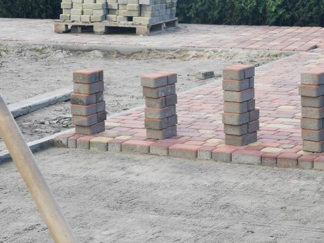 laying paving slabs on city square, repairing sidewalk