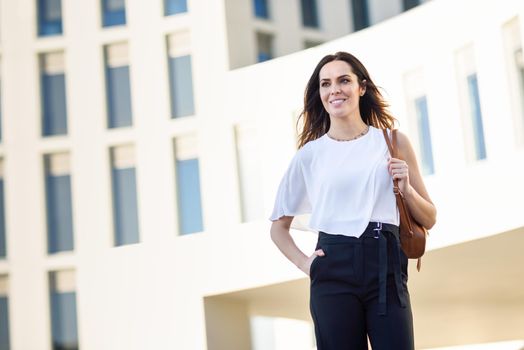 Caucasian female entrepreneur in formal clothes. Confident businesswoman standing outside an office building.