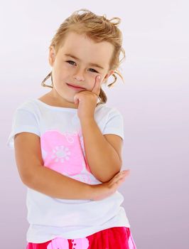 Delicate little tanned girl in a white shirt holds a hand near the face, she is dreaming and looking at the camera. Close-up.Not a purple gradient background.