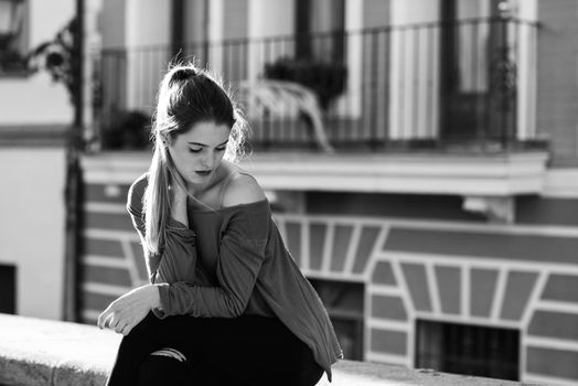 Portrait of happy blonde girl wearing casual clothes, in urban background