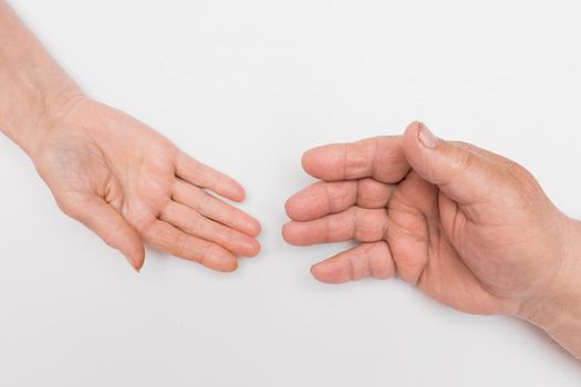 The hand of an elderly woman and an older man are drawn to each other against a white background, isolated. The concept of loving and supporting each other in old age.