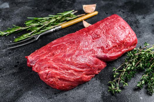 Raw fillet Tenderloin beef meat for steaks with thyme and rosemary. Black background. Top view.