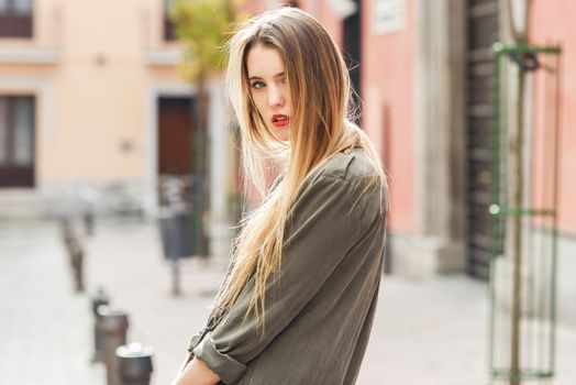Portrait of young blonde girl wearing casual clothes in urban background