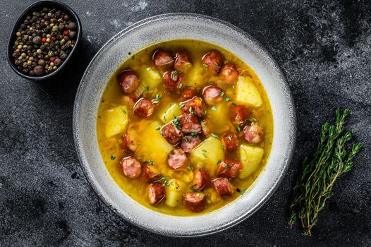 German Split pea soup with smoked sausages and meat. Black background. Top view. Copy space.