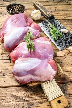 Raw Turkey thigh fillet with spices for cooking. Wooden background. Top view.