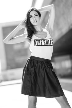 Portrait of young beautiful woman, model of fashion, wearing t-shirt and skirt