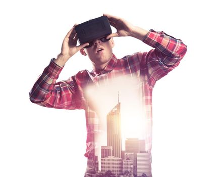 Young man with virtual reality headset or 3d glasses over cityscape background