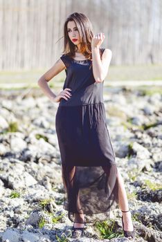 Portrait of beautiful young woman wearing long dress in a forest