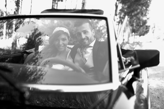 Just married couple together in an old car