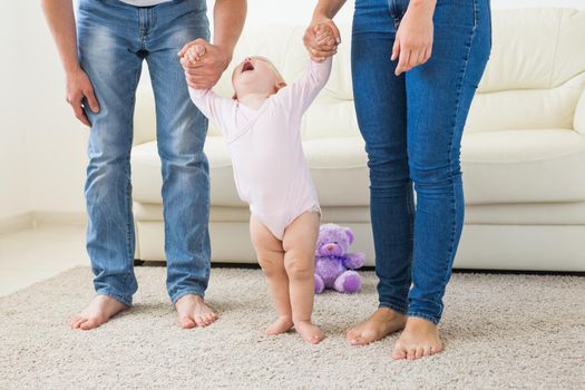 First steps. Little baby girl learning to walk. Studio shoot on white background