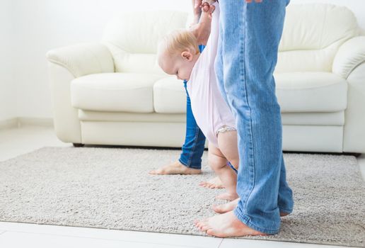 little girl first steps with the help of mom