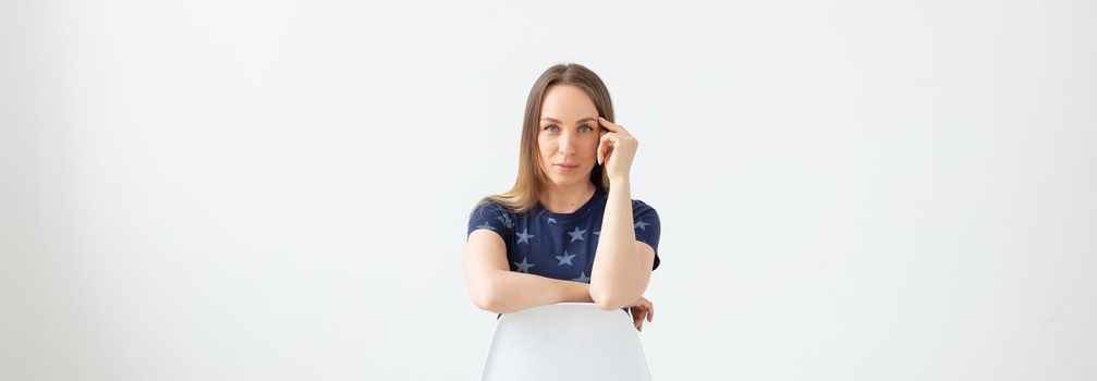 Pretty good looking stylish woman posing on white wall background. The concept of a strong independent purposeful young woman. Copyspace